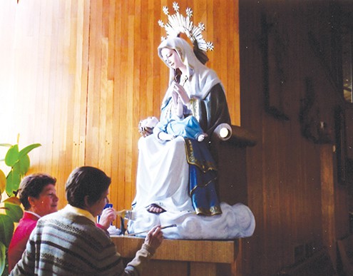 Women of the parish help prepare the statue for restoration.
