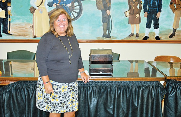 City Clerk Elaine Jasko next to the box which hold the names of the parities who qualify for a ballot position for a City Council Seat.