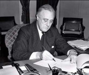 President Franklin D. Roosevelt signs the Lend Lease bill into law.
