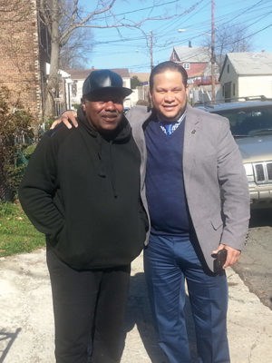 Billings contacted the Mayor’ s Office about the tree falling down on his mother’s house and car. Mayor’s Aide Irving Lozada was dispatched right away to assess the situation. Lozada said, “Code Enforcement and the Department of Public Works will be sent out immediately to assess the damage and take proper action to insure the safety of the Residents of the damaged home.” Lozada and Billings said, “The owner of the empty lot that the tree came from had 3 days to remove the tree. As of Monday morning, 4/11/16 (when the paper went to print), the tree had not been touched. (Photo Right) Woodbridge resident Jerome Billings (L) with Perth Amboy Mayor’s Aide Irving Lozada (R). 