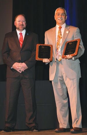 NJASBO School Business Administrator of the Year Derek J. Jess, right, is congratulated on stage at the annual conference by NJASBO President Louis Pepe.