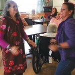 A resident and a staff member have a good time dancing