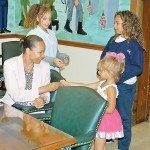 Lexani Rodriguez gives a pink ribbon to Business Administrator Jillian Barrick.