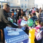 Police Officer Henry Rodgers hands out safety literature to the students