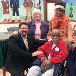 Kenneth Gonzalez greets fellow Board Member Austin Gumbs. Standing behind Gonzalez is Cherrill Garoniak and behind Gumbs is his daughter, Joycelyn Gumbs-Alsup.