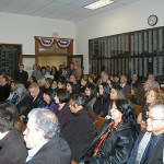 A crowded City Hall Chambers watches the swearing in