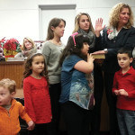 Christine Noble is sworn in by Middlesex Co. Surrogate Kevin Hoagland while some of her young family members hold the bible.