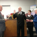 Mayor Fred Henry is sworn in by City Attorney John Lanza as his wife, Linda and his mother, Ann hold the bible.