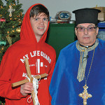Zachary Giannakopoulos, winner of the 2015 Annual Diving for the Cross displaying the Cross thrown into the frigid Raritan Bay directly across the street from the St. Demetrios Greek Orthodox Church with Reverend Father Angelo J. Michaels.