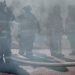 Heavy smoke surrounds some of the firefighters